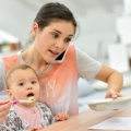 Mother feeding child while talking on phone